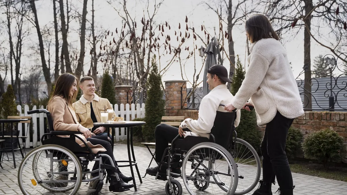 A small group at the Tenax Supports day program enjoying time together, including a participant using a wheelchair